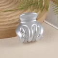 Close-up of pearl silver pumpkin hair claw clip on a minimalist wooden tray display - Gray