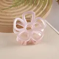 Detail einer rosa hohlen Blumen-Haarklammer mit matter Textur und Metallfeder - Rosa