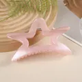 Gros plan d'une pince à cheveux étoile rose nacrée avec mécanisme à ressort en métal - Rose