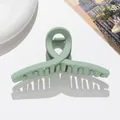 Détail d'une pince à cheveux croisée en résine vert clair mate avec ressort - 11cm / Vert