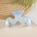Close-up of light blue wave hair claw clip on wooden tray with natural leaf background - Sky Blue