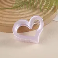 Détail d'une pince à cheveux rose mat en forme de cœur avec design évidé et ressort - Violet