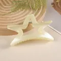 Close-up of hollow star hair claw in cream finish with a metal spring mechanism - Off White