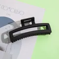 Dettaglio di una grande molletta per capelli quadrata nero opaco su sfondo minimalista - 11.5cm / Stile Rettangolare Traforato / Nero
