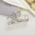 Vue détaillée d'une pince à cheveux carrée de 8cm à motif marbre sur tissu en soie - Gris Irisé