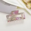 Détail d'une pince à cheveux de 8cm en acétate marbré sur un tissu en soie élégant - Rose Métallique