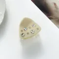 Close-up of cream star hair claw clip with rhinestones on a white aesthetic background - Beige