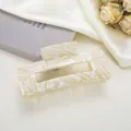 Détail d'une pince à cheveux rectangulaire effet marbre crème sur un fond de soie élégant - 10.5cm / Marbre Jaune