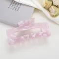 Dettaglio macro della pinza per capelli in acetato rosa marmorizzato su sfondo neutro - Rosa Olografico / 10.5cm