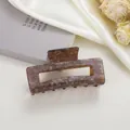 Close-up of rectangular amber acetate hair claw with floral pattern and subtle glitter - Cracked Ice Coffee