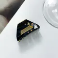 Detailaufnahme der schwarzen Haarklammer mit Herzsteinen und Goldsternen auf Acetat - 4.8*1.5cm / Schwarz
