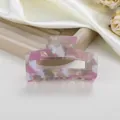 Primer plano de pinza de pelo en acetato jaspeado rosa y blanco sobre una bandeja - Rosa Hielo Picado