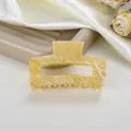 Detalle de pinza para cabello en acetato jaspeado amarillo con diseño de mármol y púas - Amarillo