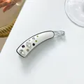 Vue détaillée d'une pince banane avec fleurs en strass et accents vert émeraude - Blanc