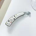 Detail of white acetate banana clip with rhinestone teardrops and black floral accents - 10cm / White