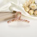 Detail of large amber marble hair claw clip with crossed design and gold metal spring - 11cm / Rock Pink