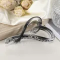 Dettaglio molletta a forma di cuore in resina grigio fumo su sfondo di seta bianca - 12cm / Nero