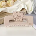 Detalle de una pinza para el pelo de oso beige en acrílico con texto Bear sobre seda - Caqui