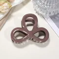 Detail of a brown bow-shaped hair claw clip with fine glitter finish and spring mechanism - 8cm / Pink