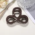 Detailed view of mocha brown glitter hair claw clip with triple hollow loop design - 8cm / Coffee