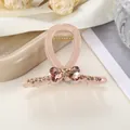Detalle de pinza para el pelo rosa con lazo de corazón de cristal y pedrería champán - 7cm / Rosa
