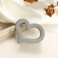 Close-up of heart-shaped matte hair claw clip in sage green on silk with dried roses - Light Gray
