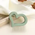 Detail view of heart-shaped light green matte hair claw clip on white silk fabric - Light Green 7cm