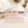 Detailopname van grote roze haarklem van hars met gouden metalen veer en antislip tanden - Waterroze