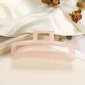 Detail van grote matroze haarklem van hars op een elegante witte zijden achtergrond - Roze Oranje