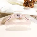 Detalle de pinza para pelo rosa con flores 3D y strass brillantes sobre seda blanca - Mediano / Rosa