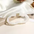 Détail d'une pince à cheveux en résine blanc perle avec ressort doré et fond en soie - 9cm / Gris clair