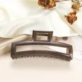 Close-up of a large translucent dark brown rectangular hair claw clip with metal spring - Dark Coffee