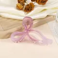 Makroansicht der Schmetterling-Haarklammer aus Acetat in Lavendel auf Seidenhintergrund - Rosa-Lila