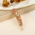Dettaglio del fermaglio a banana con finitura ambra iridescente e intarsio di gemme - Marrone