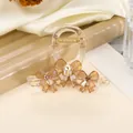 Detailed view of resin hair claw clip with bow designs and sparkling rhinestone accents - Khaki