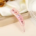 Detailansicht der rosa Bananenspange mit Perlmuttglanz und Herz-Strassverzierung - Rosa