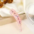 Detailansicht der rosa Bananenspange mit Strass und 3D-Blüten auf Seidenstoff - Rosa