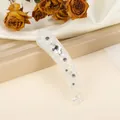 Detailed view of iridescent banana clip with shimmering rhinestones and elegant design - White