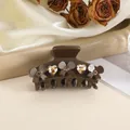 Close-up of brown bow hair claw clip with champagne heart rhinestones on satin - Coffee