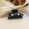 Macro shot of 5cm black hair claw clip with heart crystals and floral rhinestones - Black