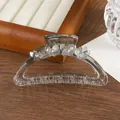 Detailed macro view of clear hair claw clip featuring frosted flowers and rhinestones - Gray