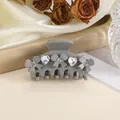 Detail of grey hair claw clip featuring heart-shaped rhinestones and floral accents - Gray