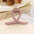 Nahaufnahme der mattrosa Haarklammer im Morandi-Stil mit Kreuzdesign auf Seide - Koreanisches Rosa