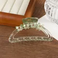 Detailed view of a clear green acrylic hair claw clip with floral pattern and rhinestones - Green
