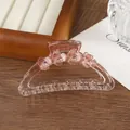 Detailed close-up of pink resin hair claw clip with floral motifs and pink rhinestones - Pink