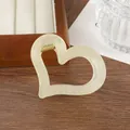 Primer plano de una pinza para el cabello de corazón hueco en resina crema con resorte - Blanco Roto
