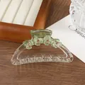 Close-up of translucent green flower hair claw clip with rhinestones and gold spring - Green