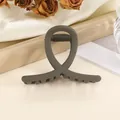 Detail of dark grey matte claw clip with sleek crossed design and strong spring grip - Coffee