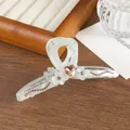 Detail van haarclip met roze hartvormige edelsteen en witte bloemaccenten - Blauw