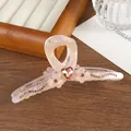 Detail van roze haarclip met bloemen en steentjes en hart op een houten dienblad - Oranje